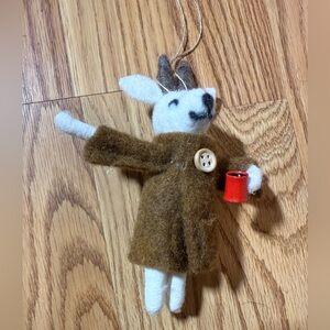 A handcrafted, needle-felted wool mouse ornament holding a red cup.